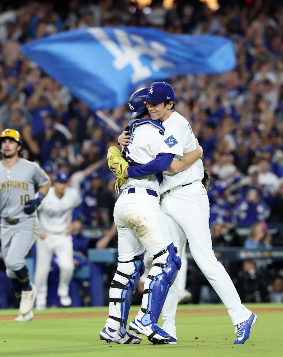 Dodgers catcher Will Smith hugs pitcher Roki Sasaki after the final out of Game 4 of the NLCS on Friday.