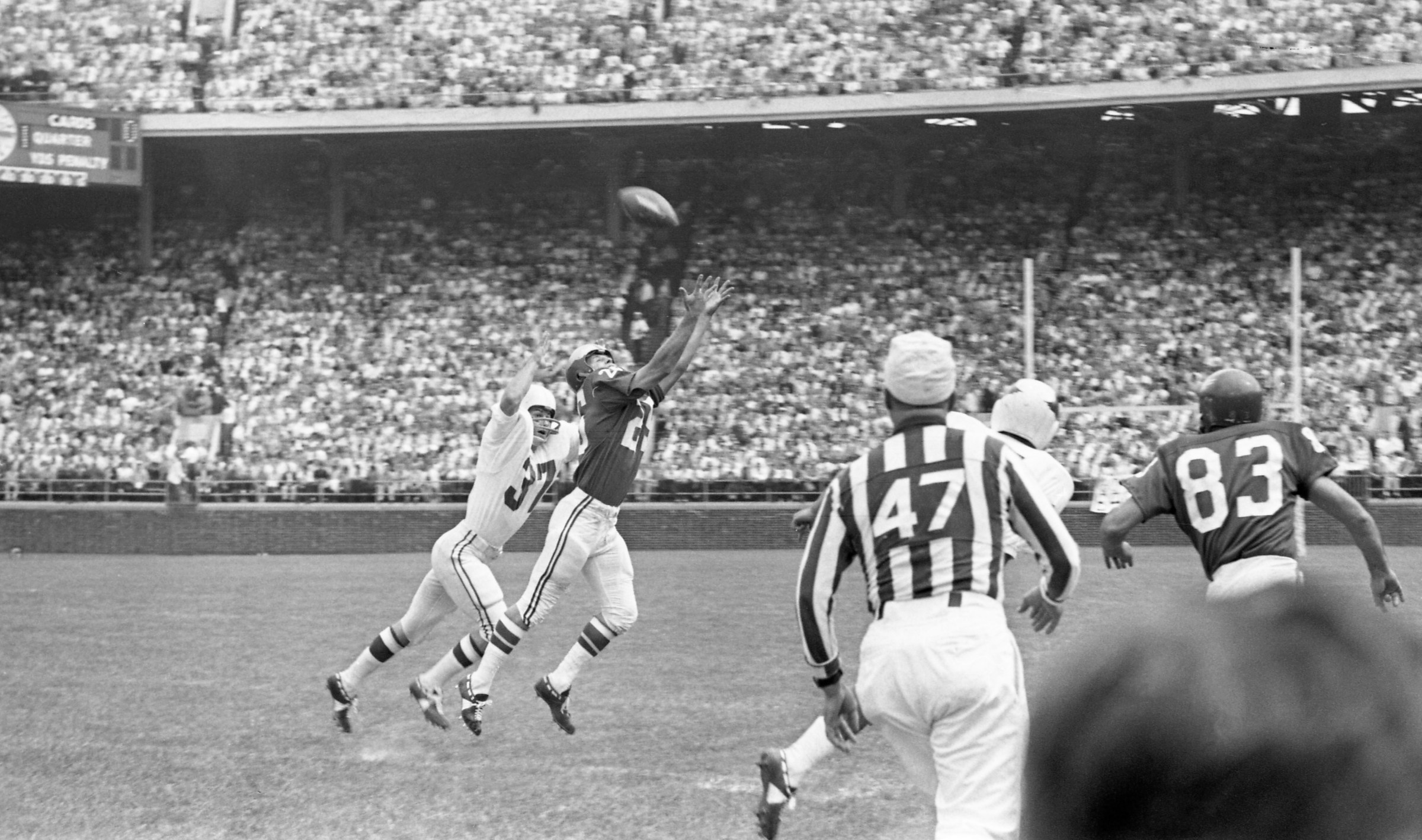 Philadelphia Eagles back Tommy McDonald (25) strains to catch the ball thrown by teammate Sonny Jurgensen as St. Louis Cardinals half-back, Pat Fischer (37) breathes down his neck. the pass was completed for a first down in the opening minutes of the game.(Photo by Bettmann Archive/Getty Images)
