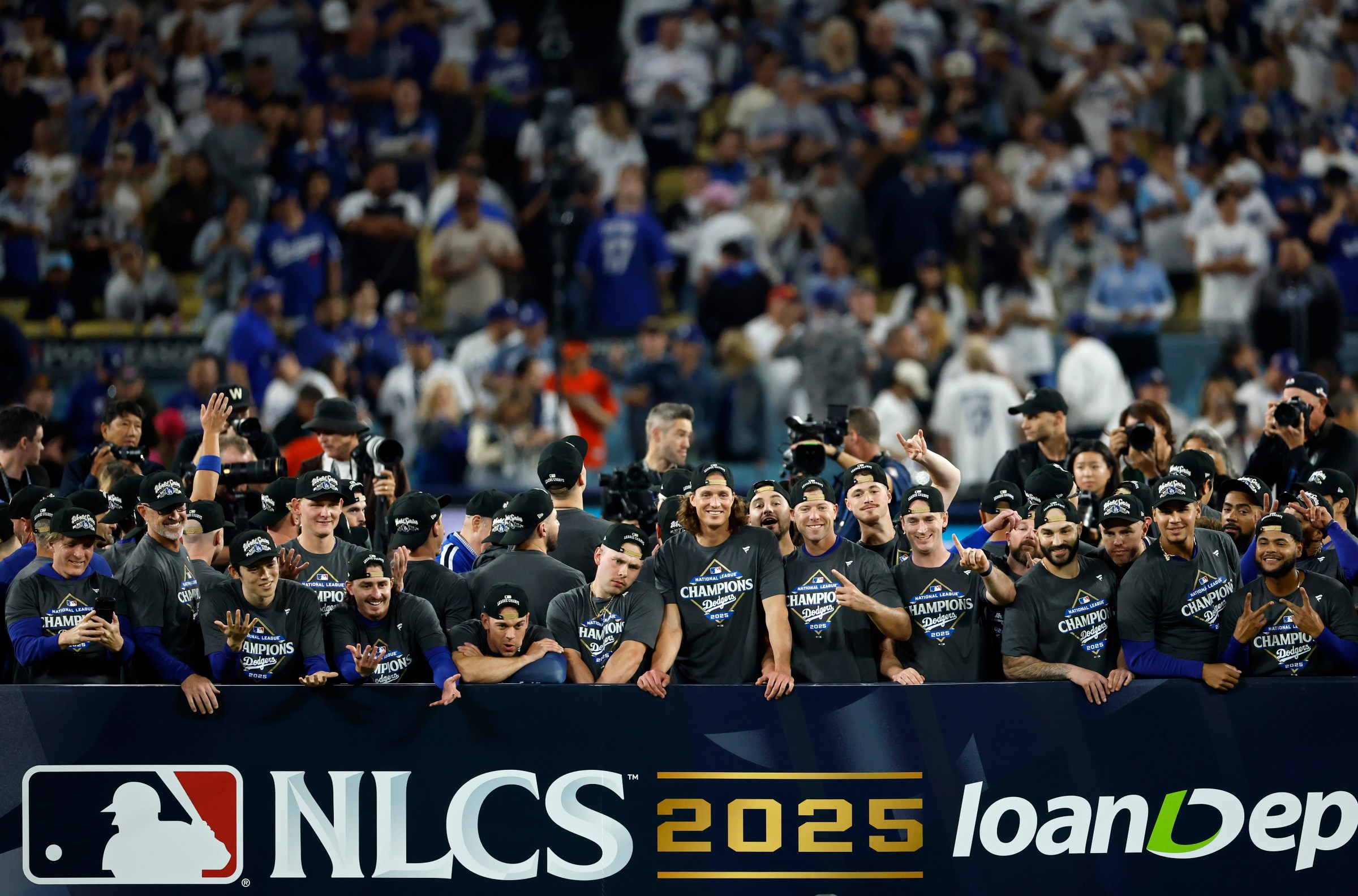 LOS ANGELES, CALIFORNIA - OCTOBER 17: The Los Angeles Dodgers pose for photo on the stage after defeating the Milwaukee Brewers 5-1 in game four of the National League Championship Series at Dodger Stadium on October 17, 2025 in Los Angeles, California. (Photo by Harry How/Getty Images)