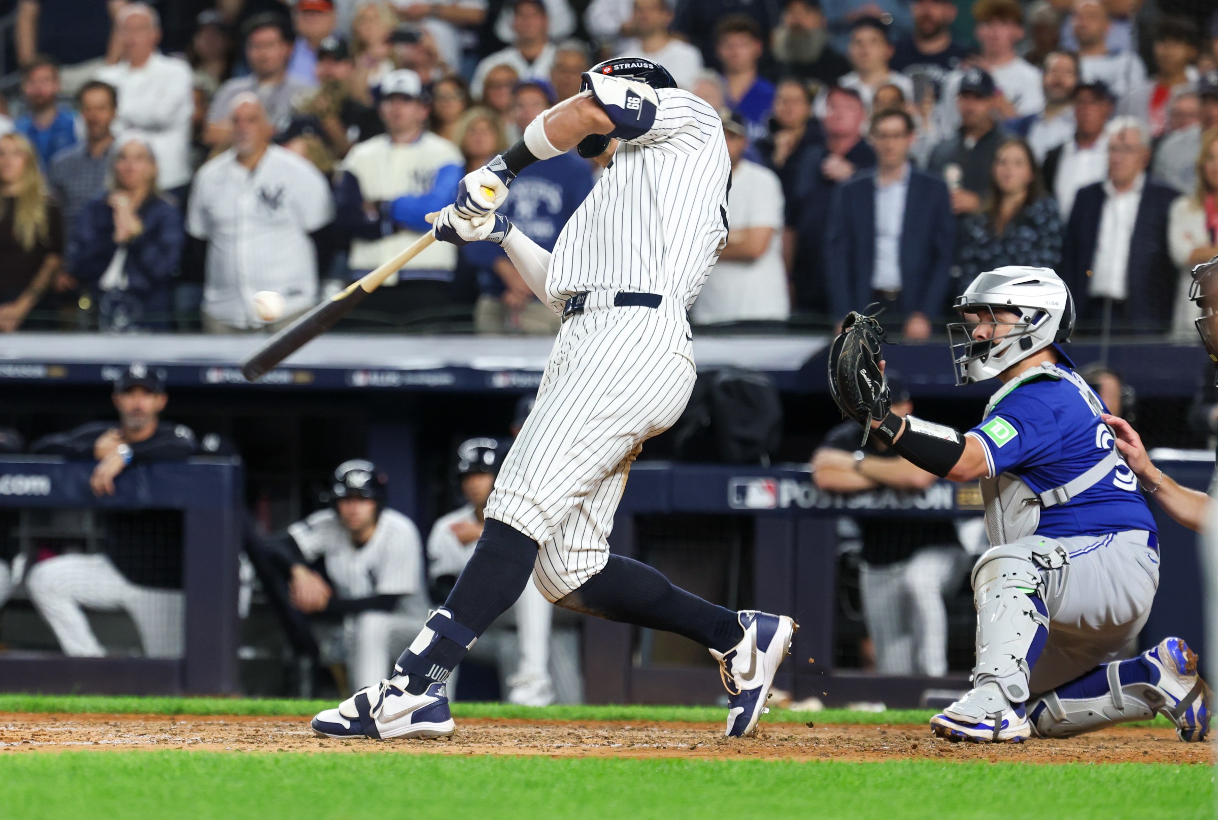 Oct 7, 2025; Bronx, New York, USA; New York Yankees outfielder Aaron Judge (99) hits a three-run home run in the fourth inning against the Toronto Blue Jays during game three of the ALDS round for the 2025 MLB playoffs at Yankee Stadium. Mandatory Credit: Vincent Carchietta-Imagn Images