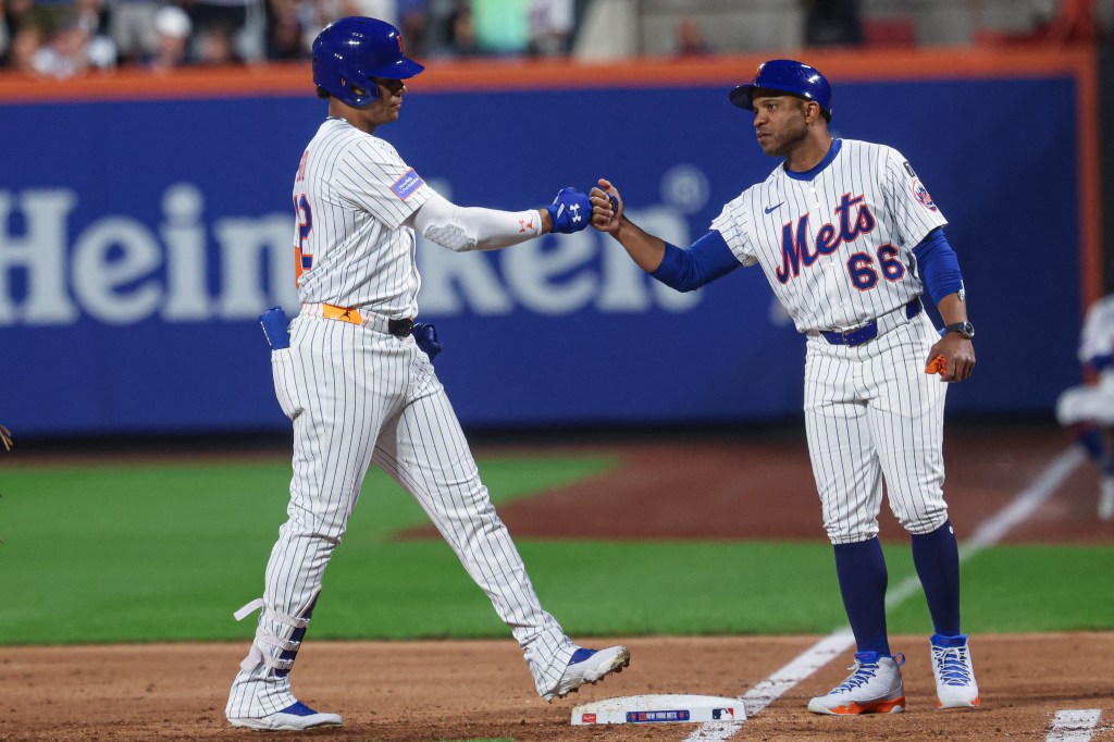 New York Mets right fielder Juan Soto and first base coach Antoan Richardson fist bump after Soto's RBI single.