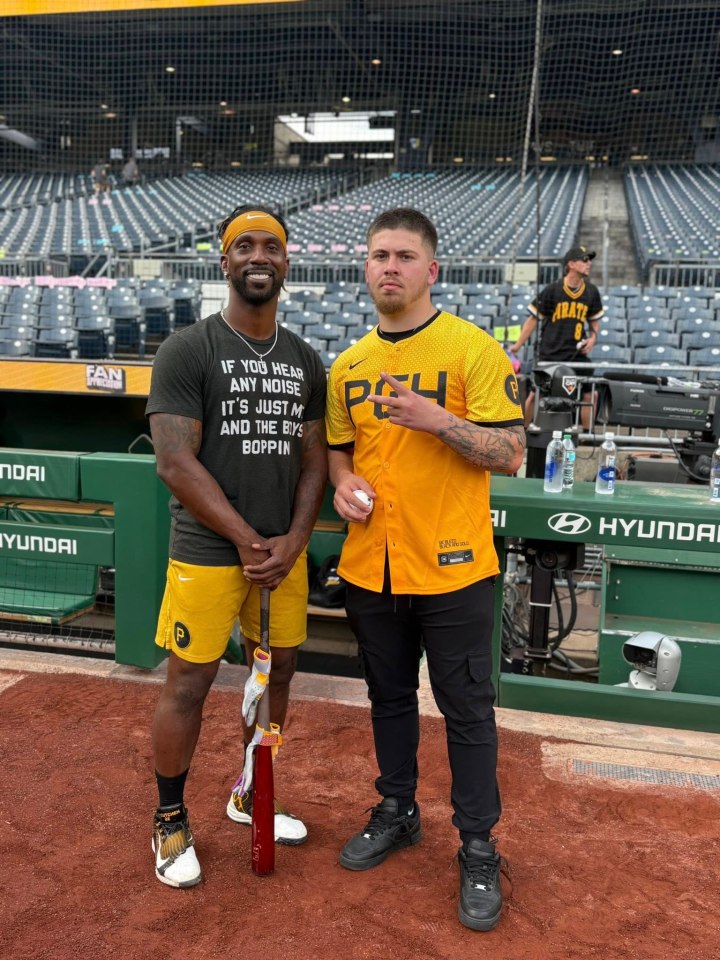 Baseball player Andrew McCutchen and a fan on a baseball field.