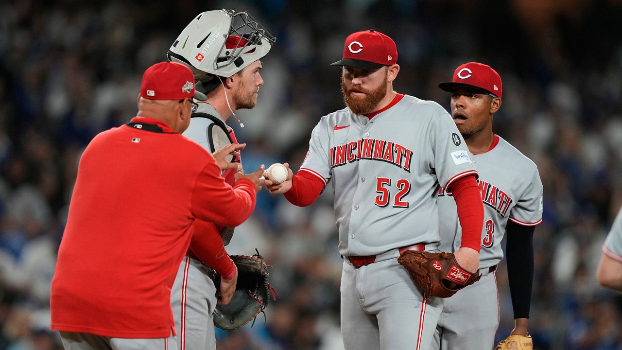 Cincinnati Reds manager Terry Francona, left, walks up to mound to replace starting pitcher Zack Littell (52) during the fourth inning in Game 2 of the National League Wild Card baseball playoff series against the Los Angeles Dodgers, Wednesday, Oct. 1, 2025, in Los Angeles. (AP Photo/Mark J. Terrill)
