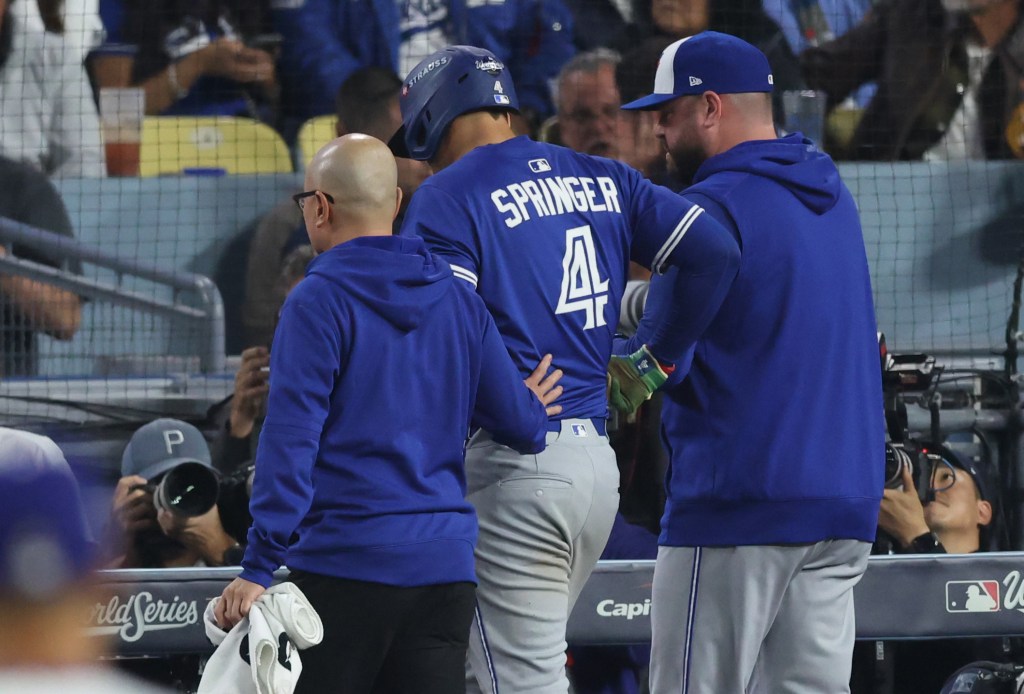 Toronto Blue Jays right fielder George Springer (4) talks to manager John Schneider (14) after an injury during the sixth inning against the Los Angeles Dodgers in game three of the 2025 MLB World Series at Dodger Stadium. 