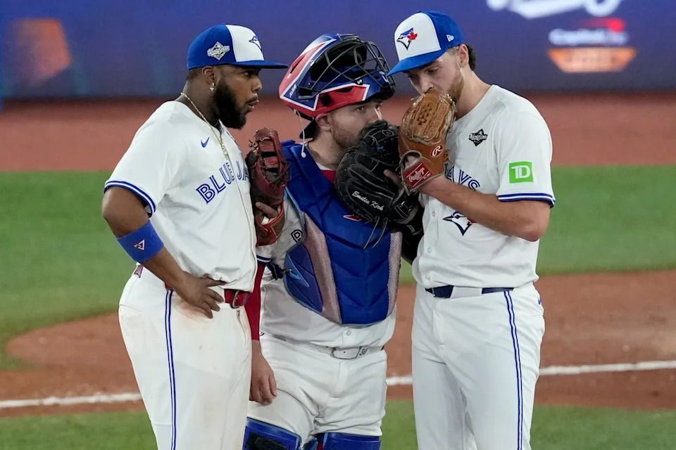 Toronto Blue Jays' Vladimir Guerrero Jr., left, and Toronto Blue Jays' Alejandro Kirk, center, talk with pitcher Trey Yesavage during the seventh inning in Game 7 of baseball's World Series against the Los Angeles Dodgers, Saturday, Nov. 1, 2025, in Toronto. (AP Photo/Ashley Landis)