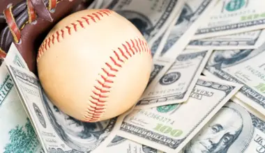 Major League Baseball sitting on a stack of cash, symbolizing player salaries and high-value contracts.