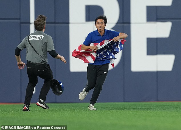 A World Series fan waving an American flag invaded the field in Toronto on Friday night