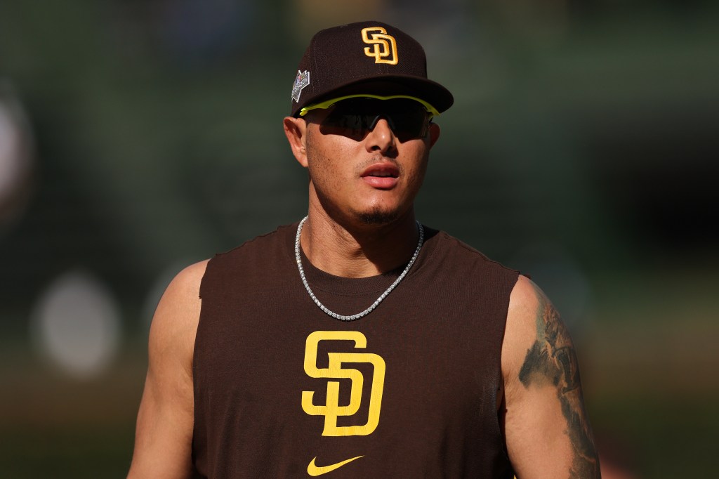 Manny Machado of the San Diego Padres wearing a brown cap and sleeveless shirt with the Padres logo and sunglasses.