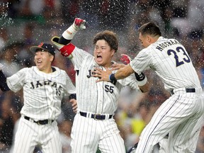 Munetaka Murakami (centre) of Team Japan celebrates with teammates after hitting a two-run double to defeat Team Mexico at the World Baseball Classic in 2023.