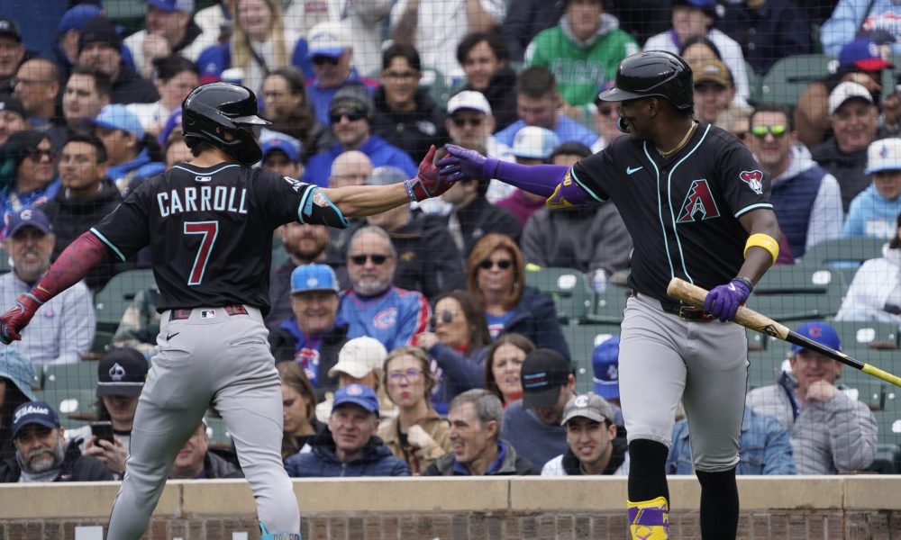 Apr 19, 2025; Chicago, Illinois, USA; Arizona Diamondbacks outfielder Corbin Carroll (7) is greeted by shortstop Geraldo Perdomo (2) after hitting a home run against the Chicago Cubs during the first inning at Wrigley Field. Mandatory Credit: David Banks-Imagn Images