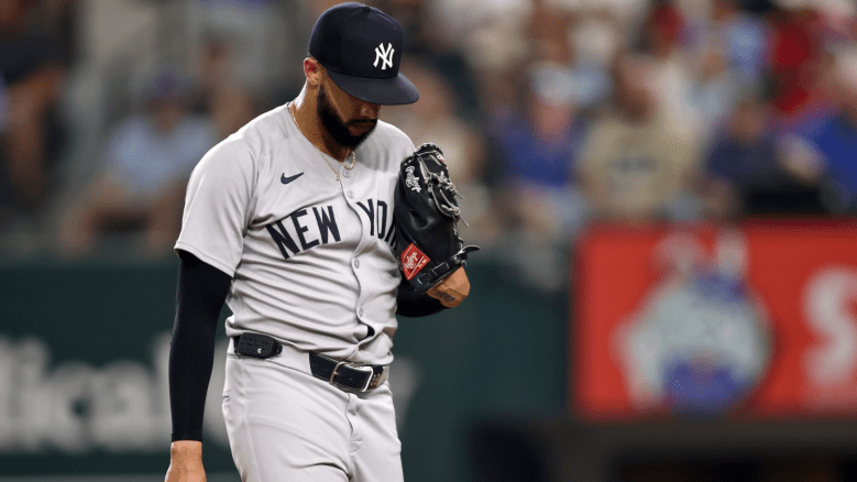 Yankees pitcher Devin Williams reacts after blowing a save against the Rangers as manager Aaron Boone looks on during a rough August 2025 series.