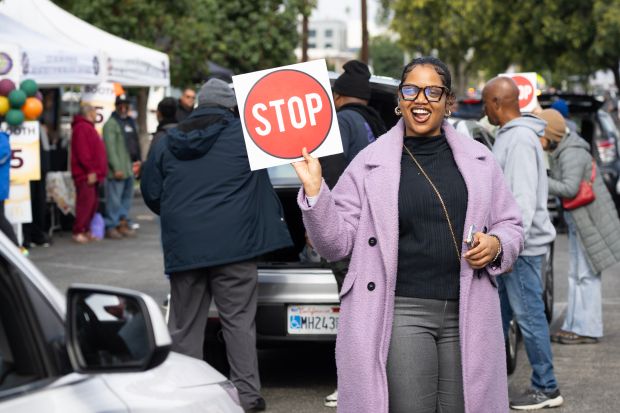 Volunteer Kyara Winston directs traffic during the annual Thanksgiving grab-and-go...