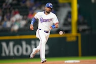Texas Rangers' Marcus Semien runs the bases on a fly out by Adolis García during the second...