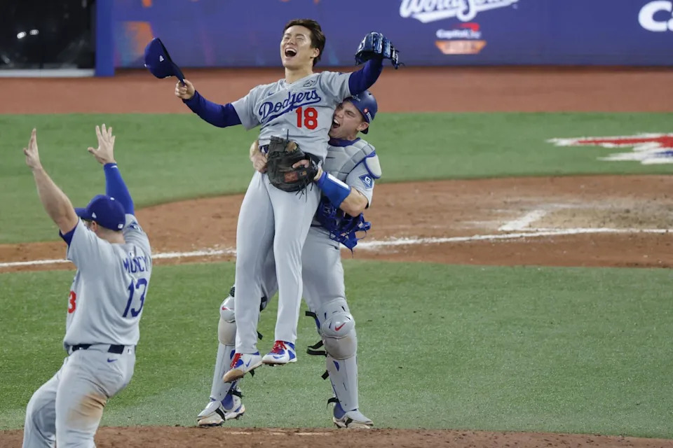 Dodgers catcher Will Smith picks up Dodgers pitcher Yoshinobu Yamamoto after the final out.