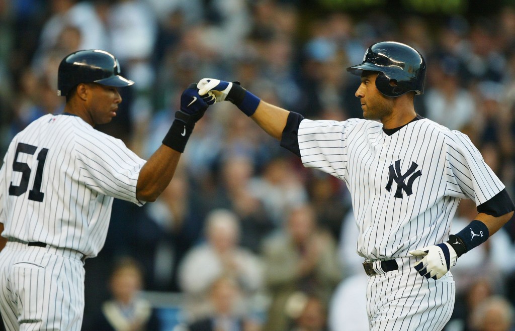 Derek Jeter and Bernie Williams celebrating a home run with a fist bump.