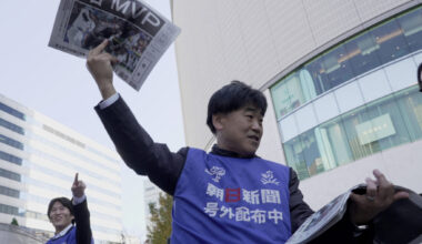 A staff from Asahi Newspaper holds up an extra edition about Los Angeles Dodgers two-way player Shohei Ohtani's MVP award ...