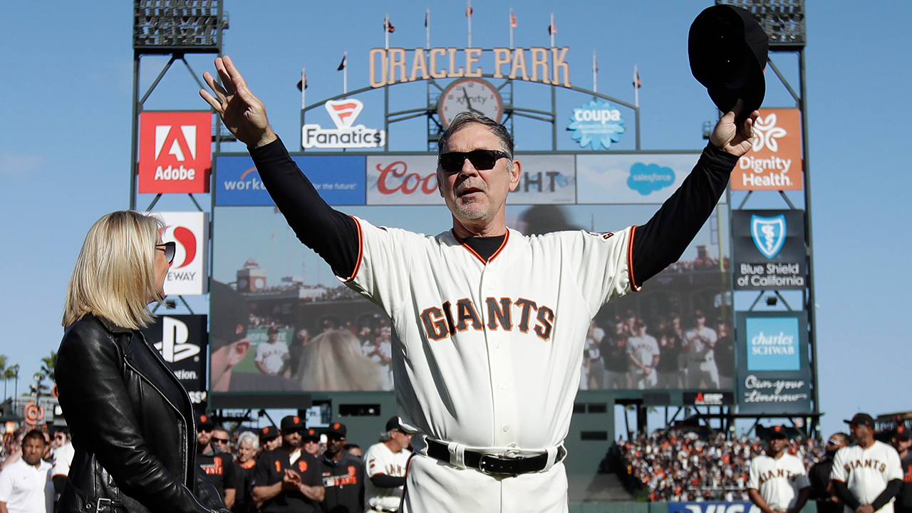 San Francisco Giants manager Bruce Bochy, center, gestures toward fans next to his wife Kim during a ceremony honoring Bochy after a game between the Giants and the Los Angeles Dodgers. (Jeff Chiu/AP)