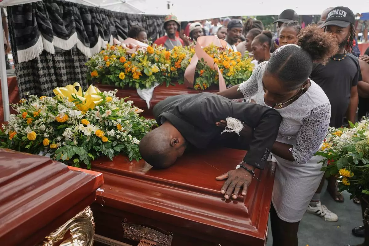 Relatives of Rosiclaire Lenchise mourn during the funeral of victims killed by a landslide triggered by Hurricane Melissa in Petit Goave, Haiti, Saturday, Nov. 15, 2025. (AP Photo/Odelyn Joseph)