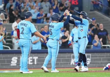Aug 12, 2025; Toronto, Ontario, CAN; Toronto Blue Jays third baseman Ernie Clement (22) hits a three run home run and celebrates with centre fielder Daulton Varsho (5) against the Chicago Cubs during the fourth inning at Rogers Centre. Mandatory Credit: Nick Turchiaro-Imagn Images