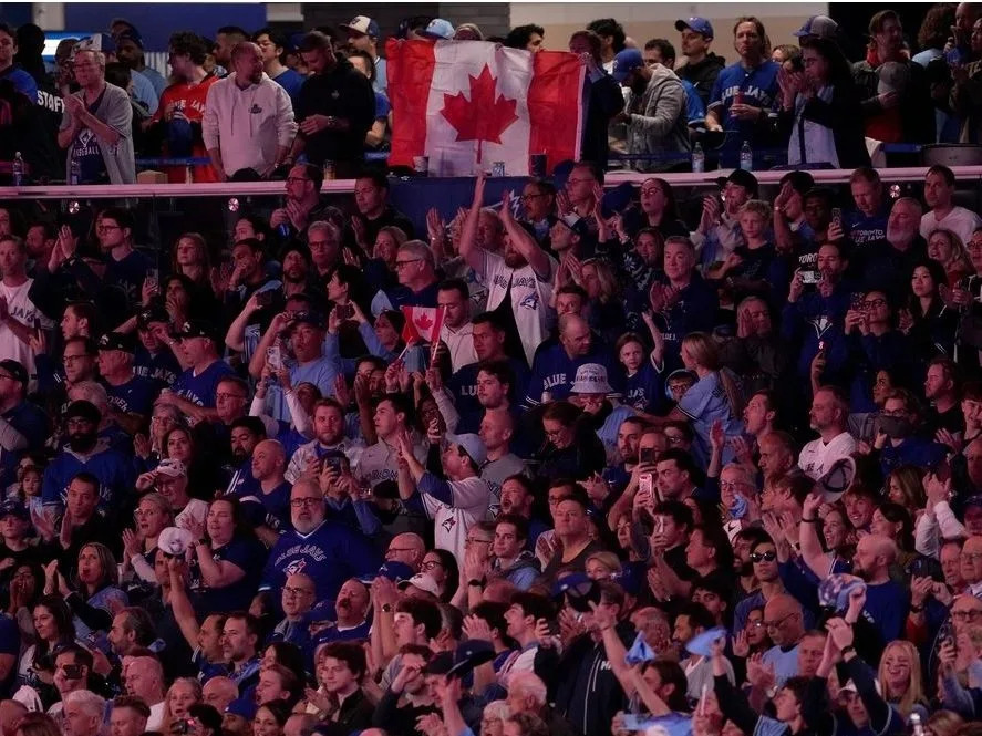  Fans wave the Canadian flag during the national anthem prior to Game 2 of the World Series between the Los Angeles Dodgers and Toronto Blue Jays, Saturday, Oct. 25, 2025, in Toronto.