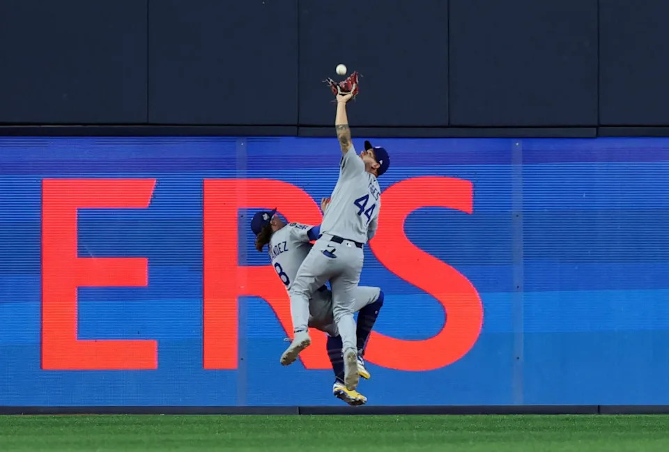 Center fielder Andy Pages (44) reaches to catch the fly ball in game seven.