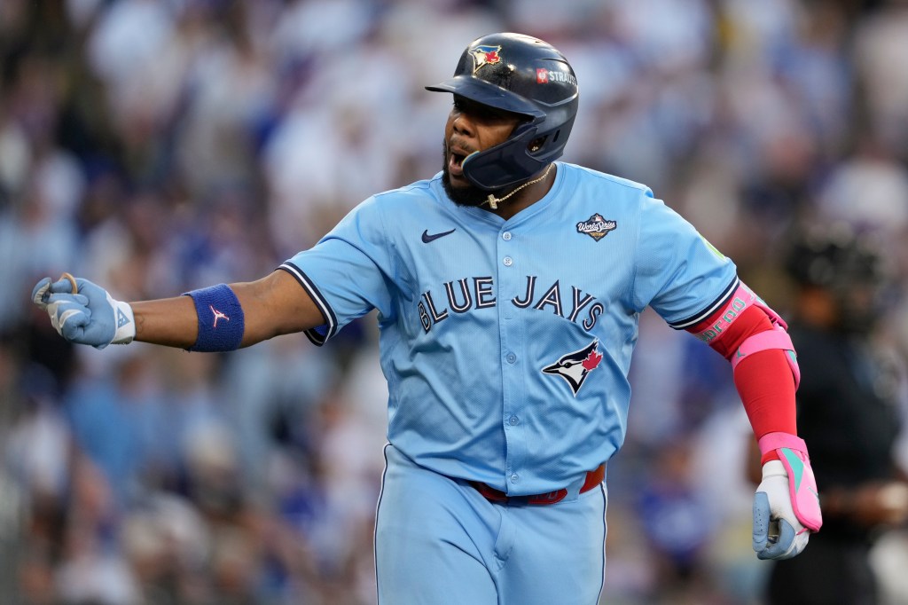 Toronto Blue Jays player in a light blue jersey, batting helmet, and a World Series patch.