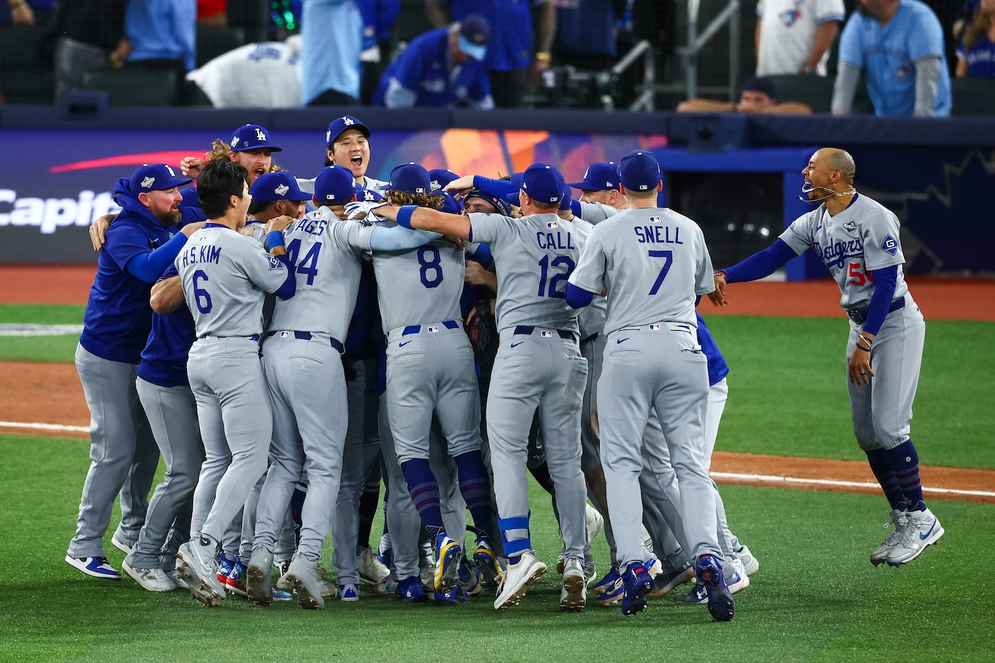 Mookie Betts #50 of the Los Angeles Dodgers (R) celebrates with teammates after defeating the Toronto Blue Jays 5-4 in Game 7 of the 2025 World Series.