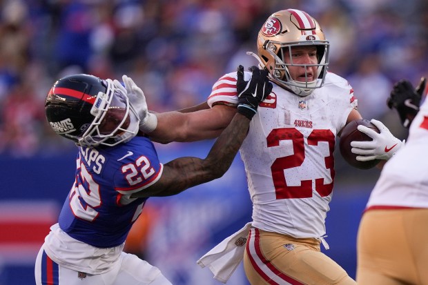 San Francisco 49ers running back Christian McCaffrey (23) stiff-arms New York Giants cornerback Andru Phillips (22) during the third quarter of an NFL football game, Sunday, Nov. 2, 2025, in East Rutherford, N.J. (AP Photo/Frank Franklin II)