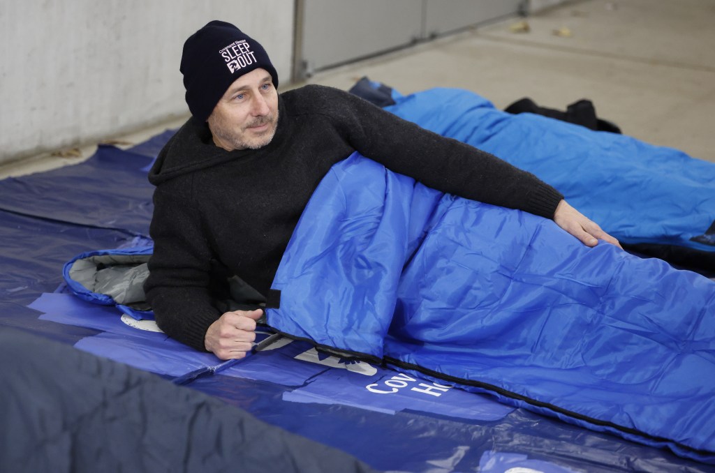 Yankees general manager Brian Cashman is seen in his sleeping bag during the Covenant House Sleep Out event at the Jacob Javits Center.