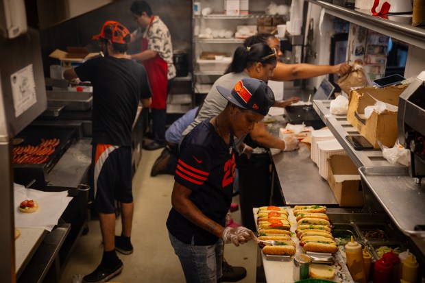 The kitchen at The Wiener's Circle works to fulfill its...