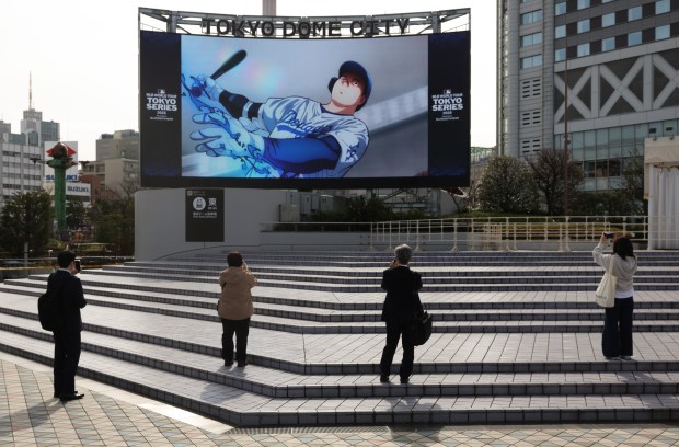 A group of people record a video screen showcasing Dodgers...