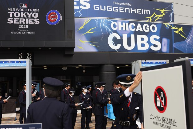 Security workers prepare to let in fans to watch team...