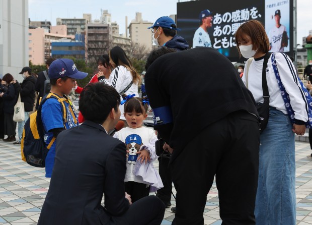 A child is interviewed by a reporter outside the Tokyo...