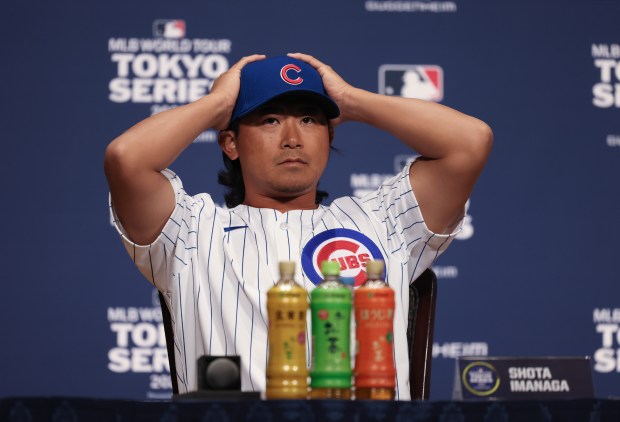 Cubs pitcher Shota Imanaga adjusts his cap while taking questions...