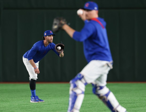 Cubs infielder Dansby Swanson, left, works out with teammates in...