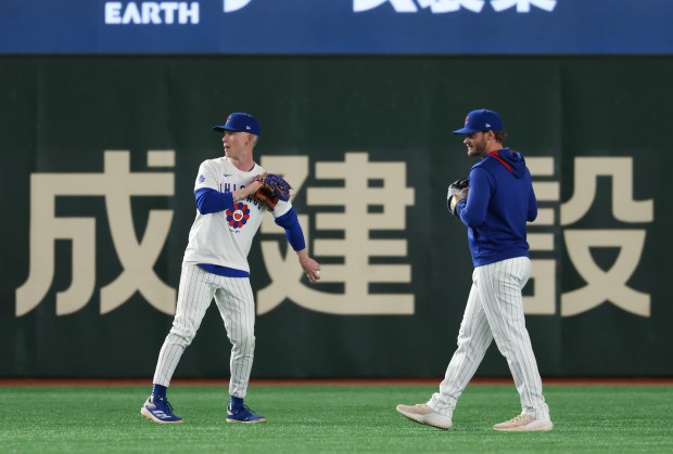 Cubs outfielders Pete Crow-Armstrong, left, and Ian Happ work out...