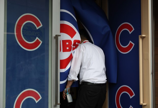 A worker enters through a Chicago Cubs curtain entrance to...
