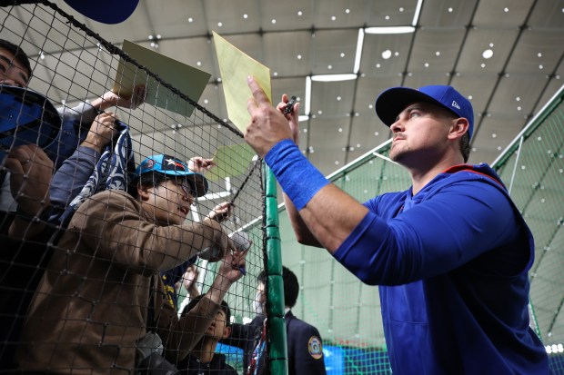 Cubs catcher Reese McGuire signs autographs before an exhibition game...