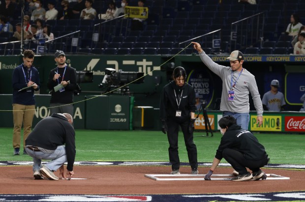 Distances are measured for the batter's box placement before an...