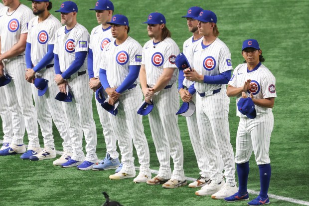 Chicago Cubs pitcher Shota Imanaga, right, and teammates stand during...