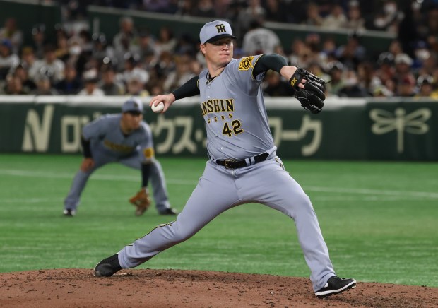 Hanshin Tigers pitcher Nick Nelson throws against the Cubs in...