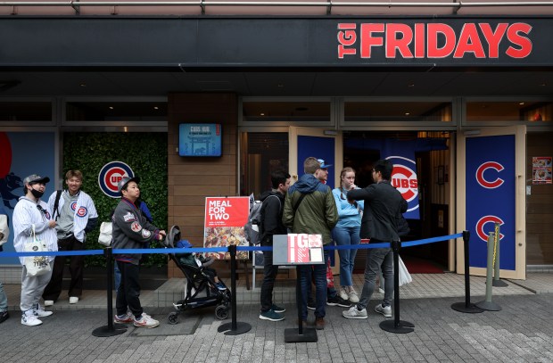 Fans wait to enter a TGI Fridays restaurant hosting a...