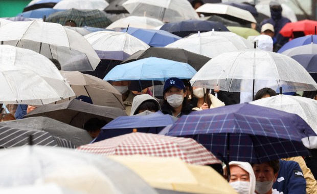Baseball fans exit in the rain after the Hanshin Tigers...