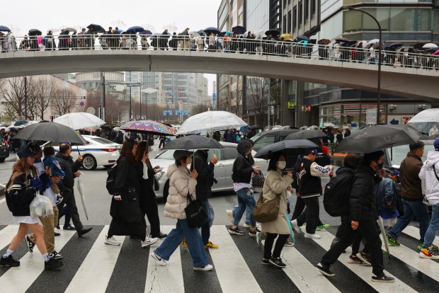 Baseball fans exit in the rain after the Hanshin Tigers...