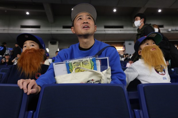 Kanji Oishi watches batting practice with his sons, Hiroto, 8,...