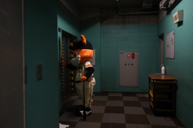 A mascot for the Yomiuri Giants presses a freight elevator...