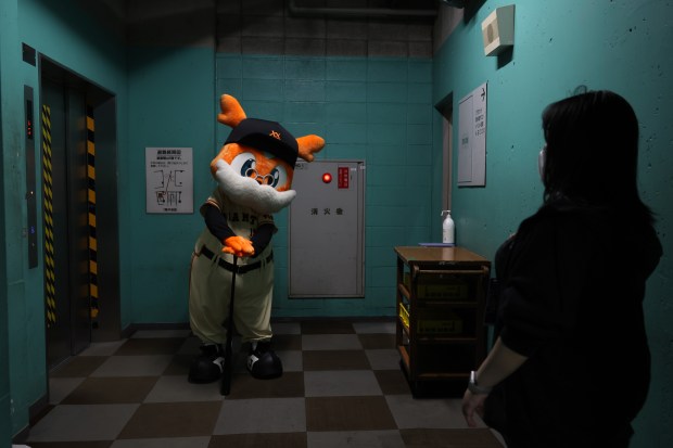 A mascot for the Yomiuri Giants waits for a freight...