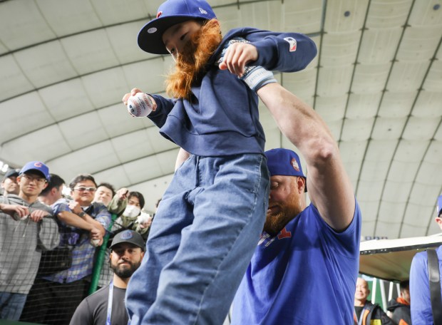 Chicago Cubs first baseman Justin Turner lifts Hiroto Oishi, 8,...
