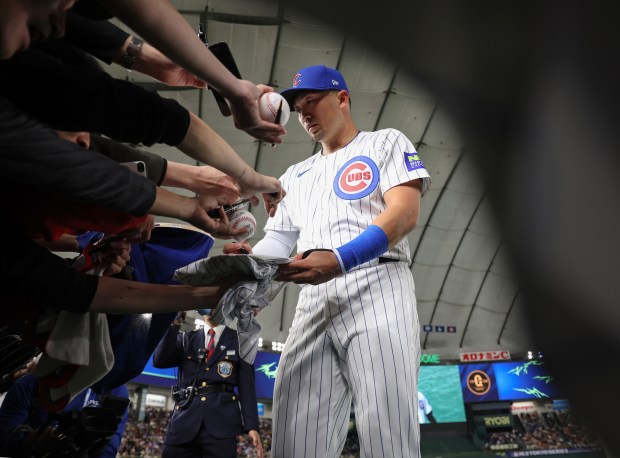 Chicago Cubs outfielder Seiya Suzuki signs autographs before an exhibition...