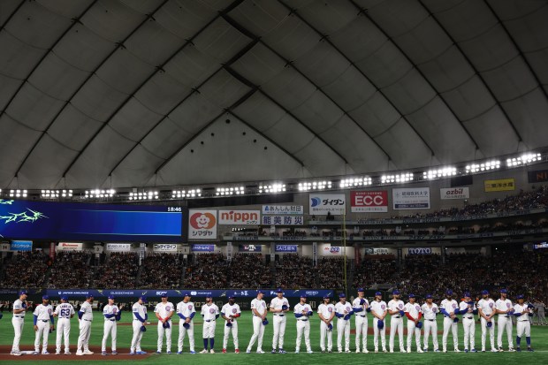 Cubs players and coaches line up for introductions before an...